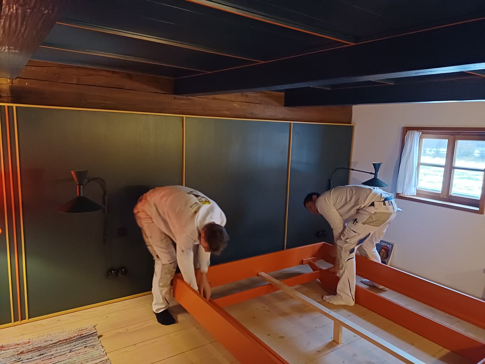 Two Hierat painters lacquering fitted wardrobes in a bedroom