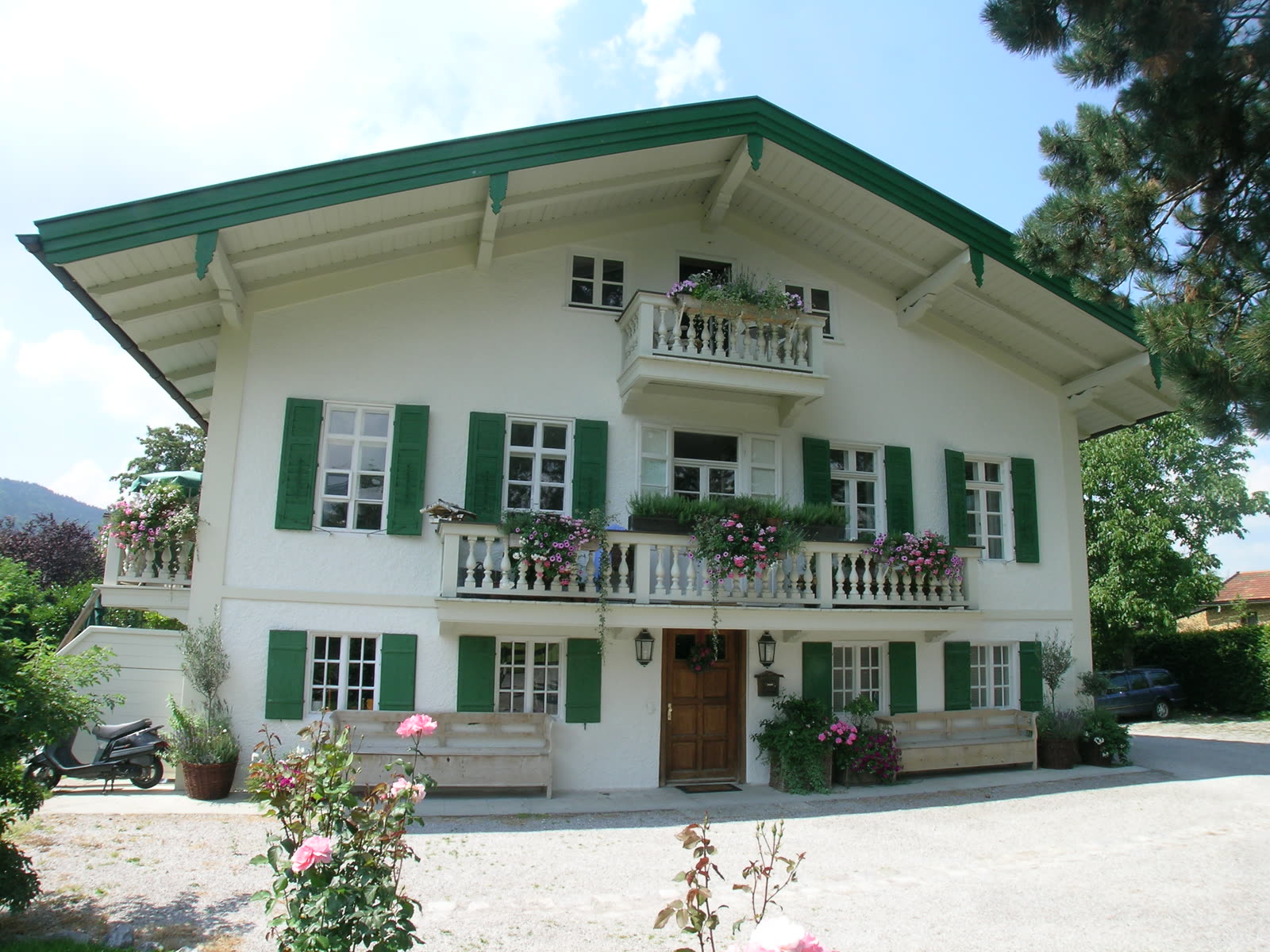 Villa with a white facade, green shutters and balconies