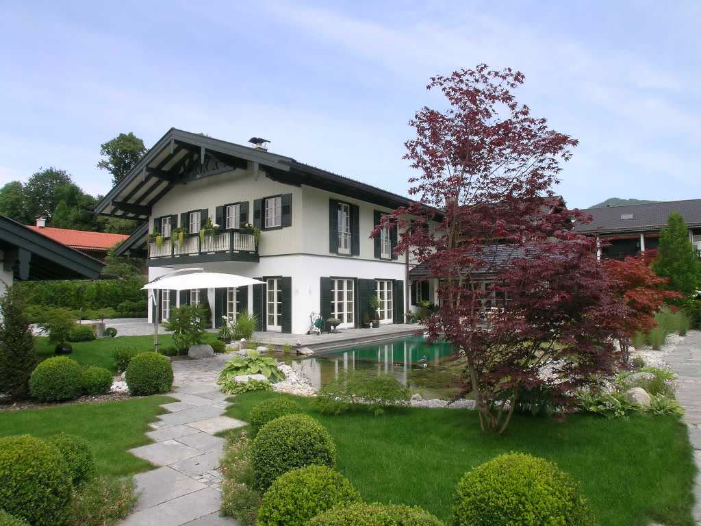 Country house with a designed facade, timber balcony and garden