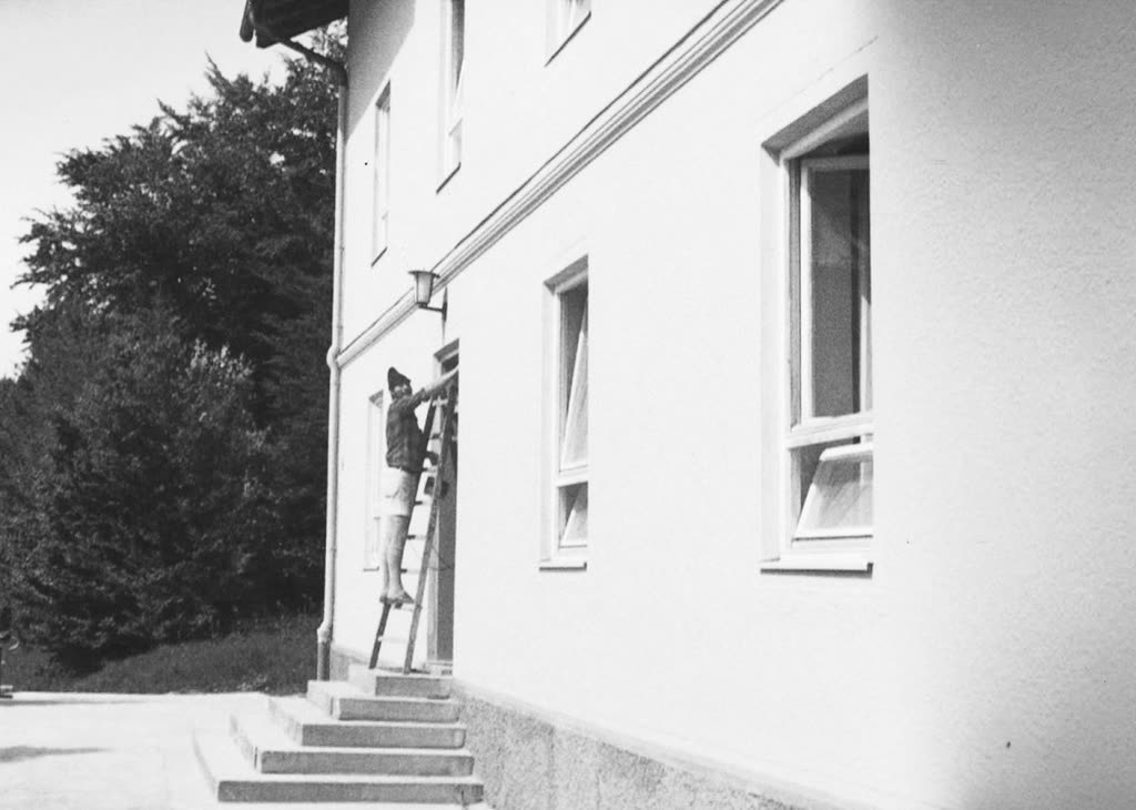 Historical photo: painter on a ladder painting a facade