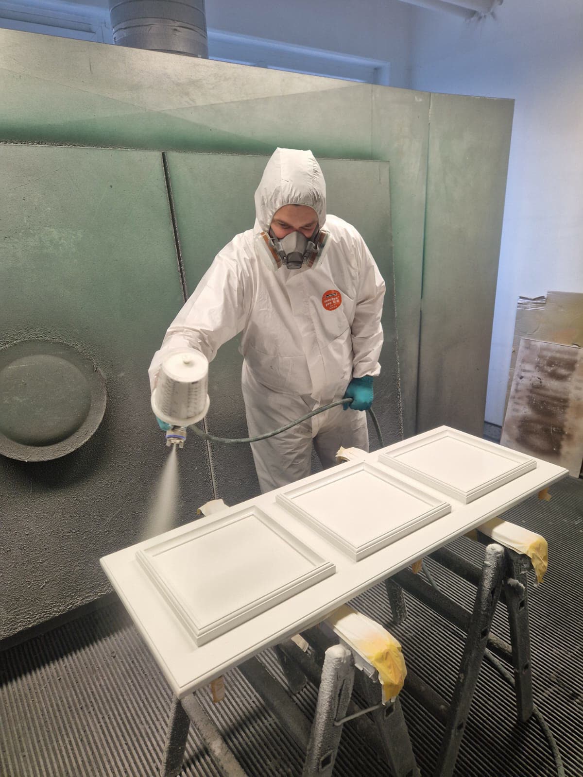 Door being spray-lacquered white in the Hierat spray booth
