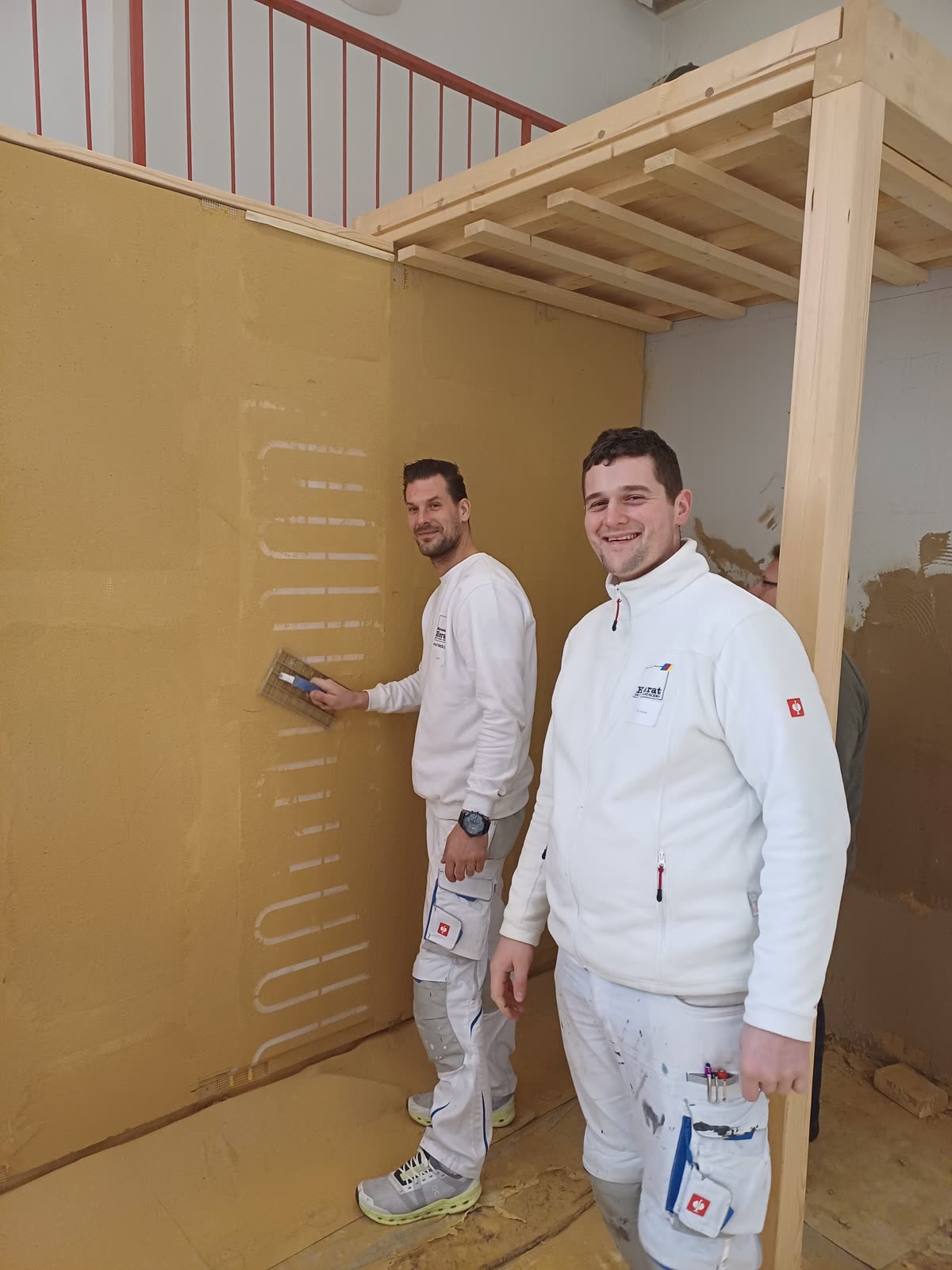Two Hierat painters applying clay plaster to a wall