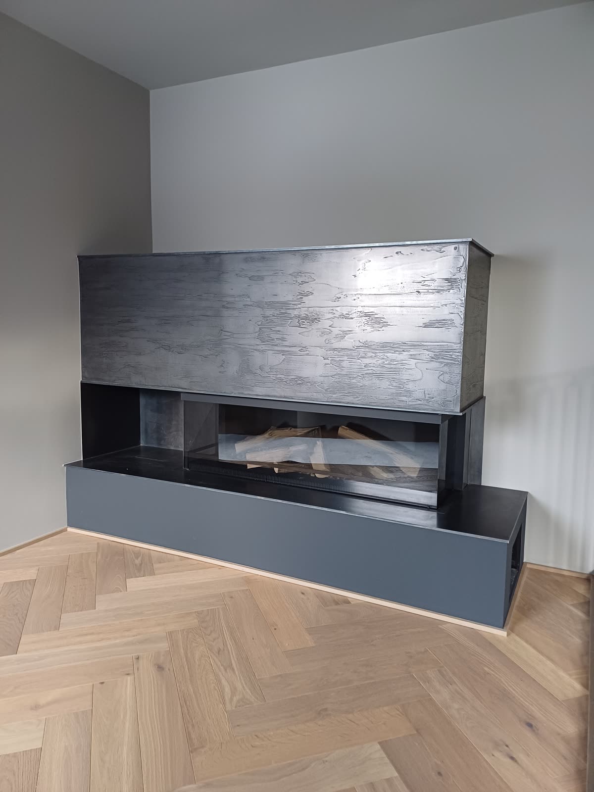 Fireplace surround with a dark metallic surface