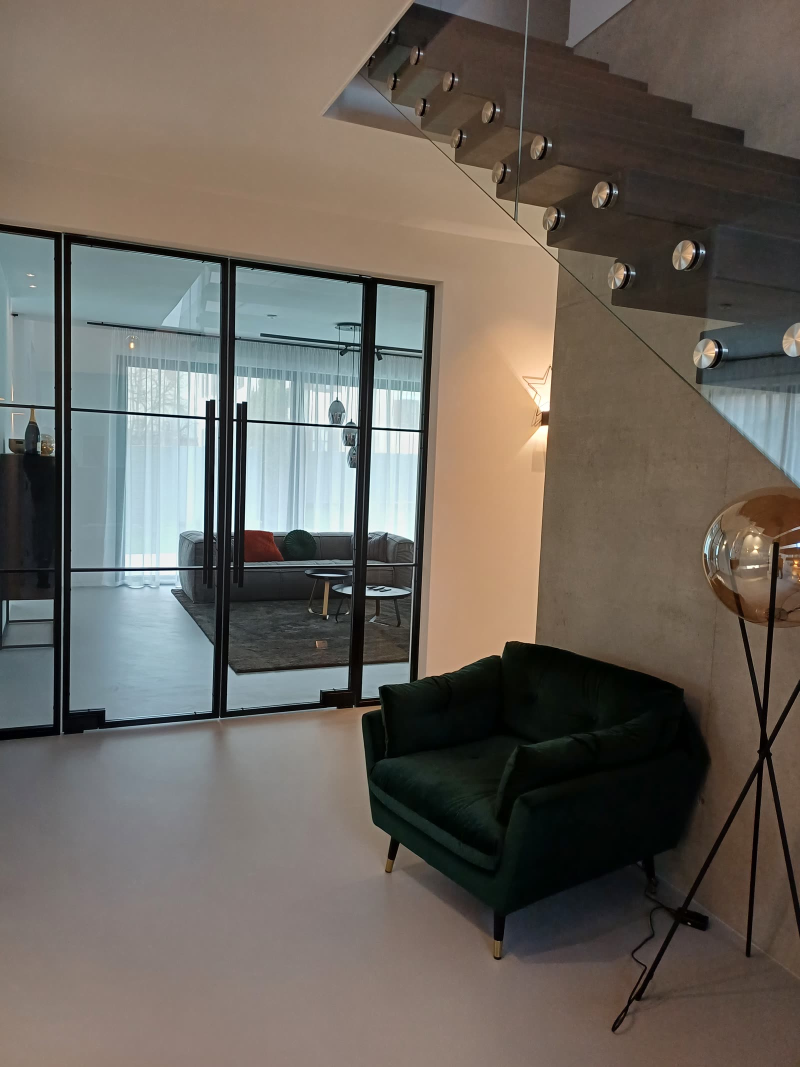 Seamless floor with a trowelled wall in a concrete look beneath a staircase
