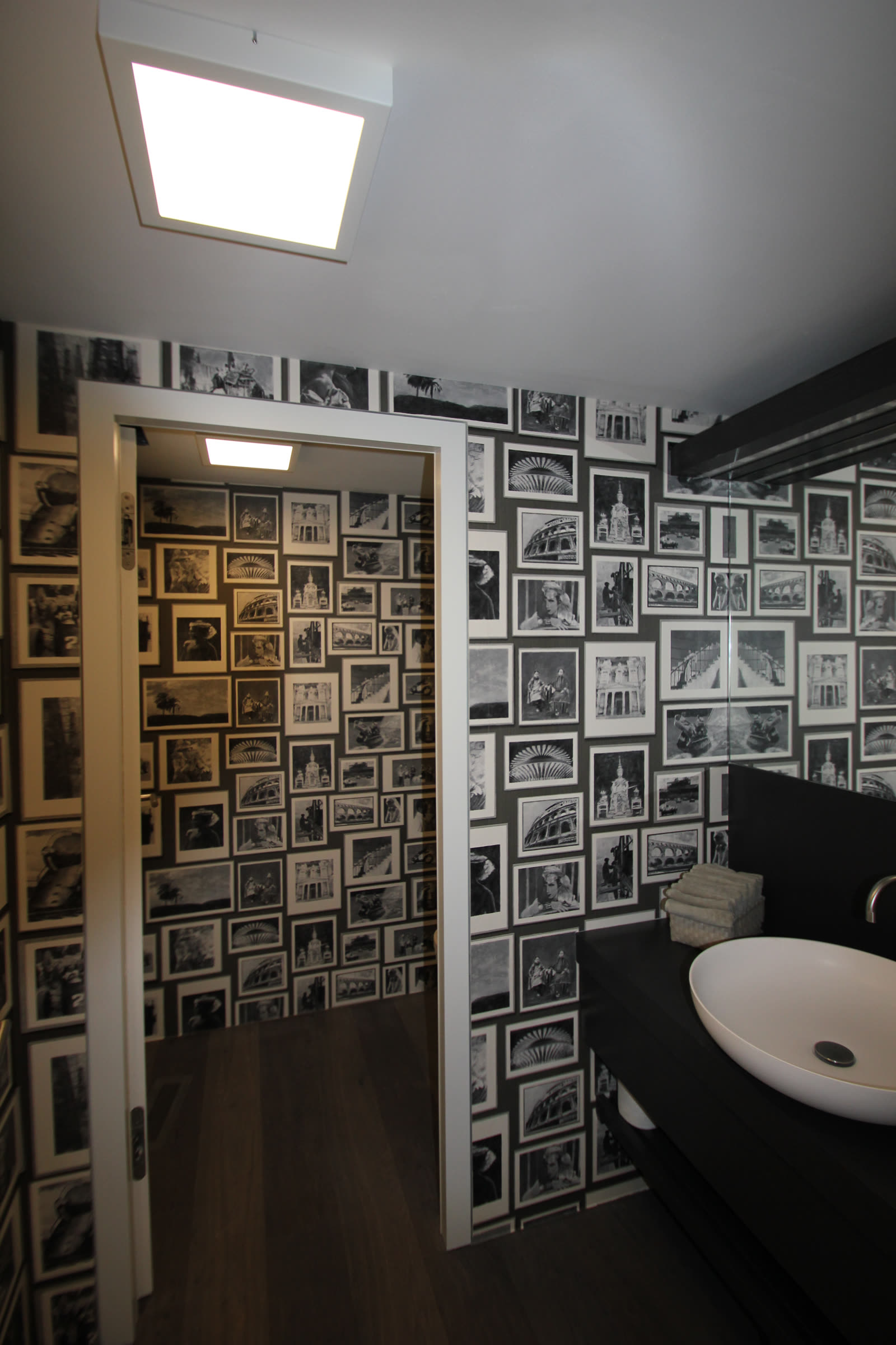 Guest toilet with a wall mural of black and white picture frames